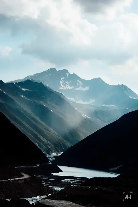 Sunlit mountain ridges falling to a lake in a northern valley