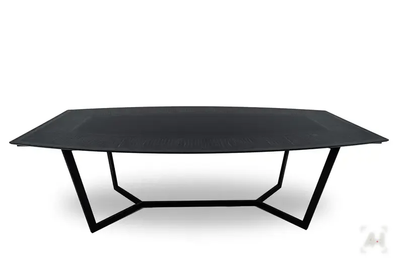 A black dining table with an engraved border on angled steel legs