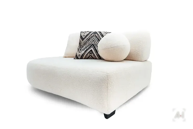 A single armless bouclé module with a chevron cushion and a ball pillow