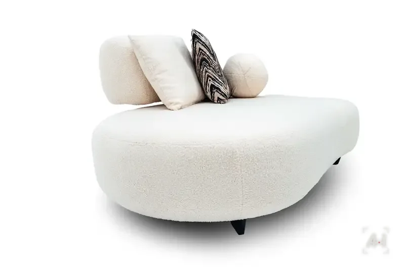 The rounded bouclé chaise end in profile