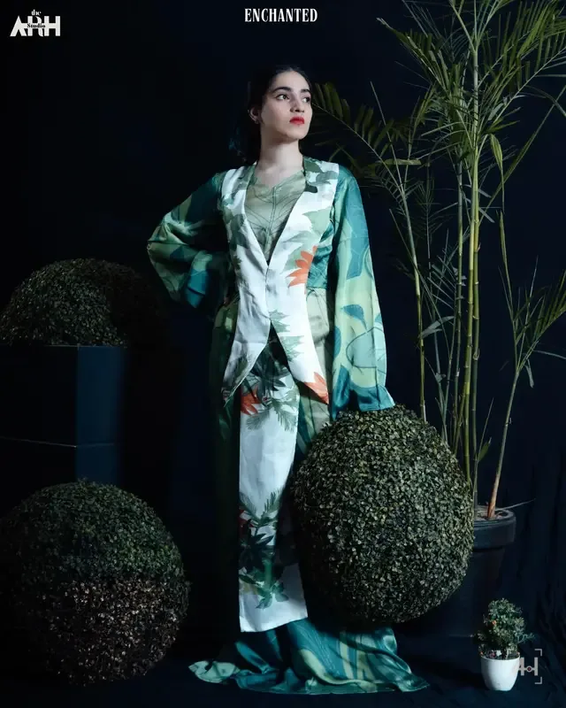 Enchanted's palm-print co-ord against a black studio wall
