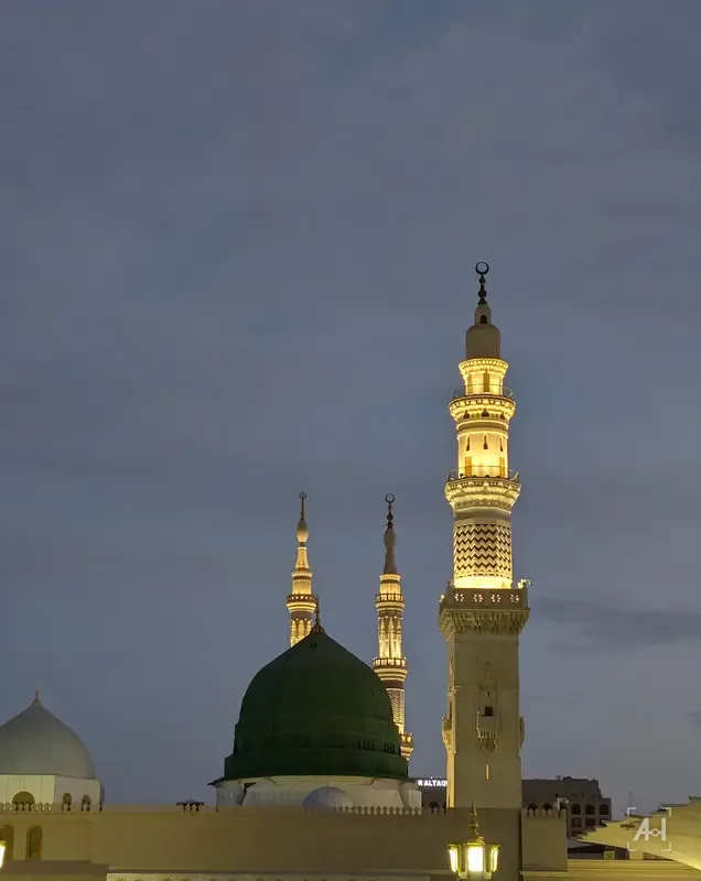 The Green Dome and a lit minaret of the Prophet's Mosque at blue hour
