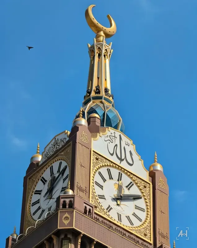 The gold crescent and clock faces of the Makkah Royal Clock Tower against a blue sky
