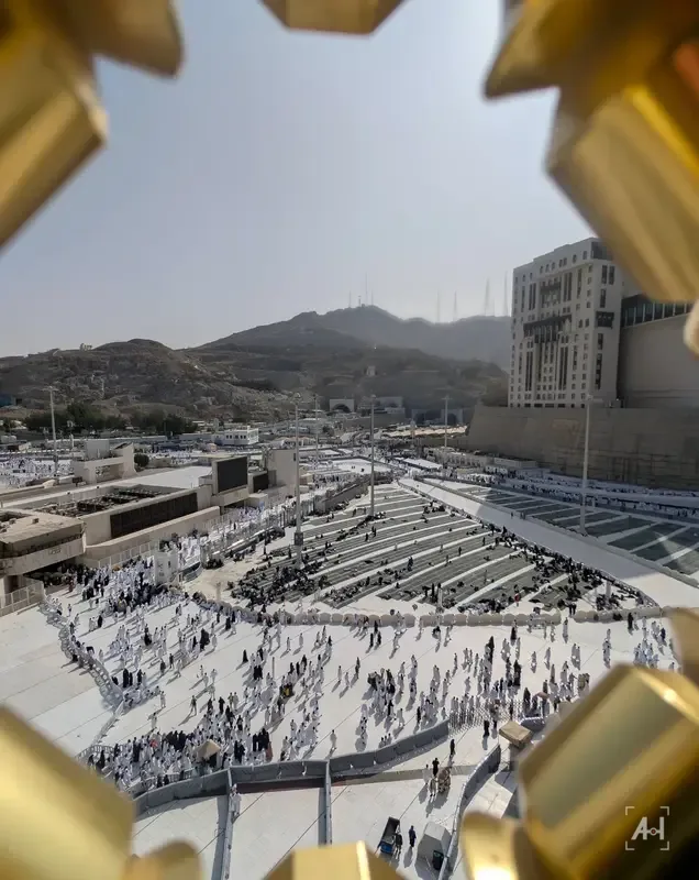 The Haram courtyard and the hills of Makkah seen through a gold star-shaped frame