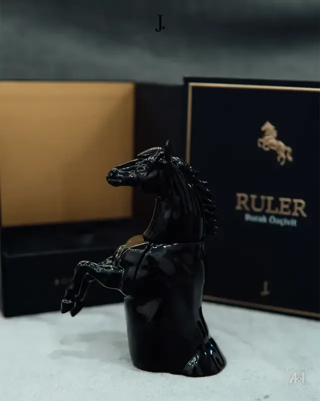 The black horse bottle of Ruler by J. in front of its gold-lettered box