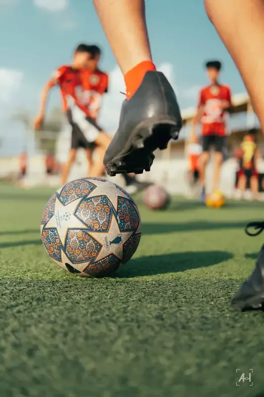A Champions League ball at boot level, an academy side training behind