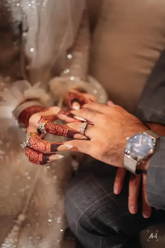 The couple's hands, rings and a watch, close together
