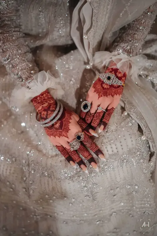 Henna hands resting on an embroidered dress