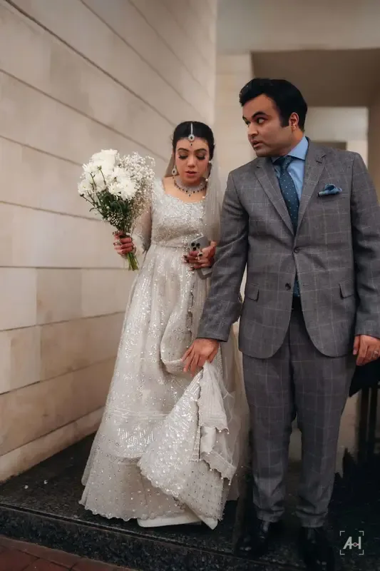 The newly married couple walking out, bouquet in hand